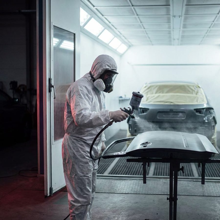Lackierer bei der Arbeit in der Lackierkabine